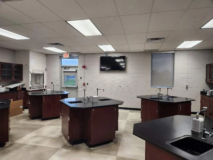 Science classroom lab with a wall-mounted display above the lab stations