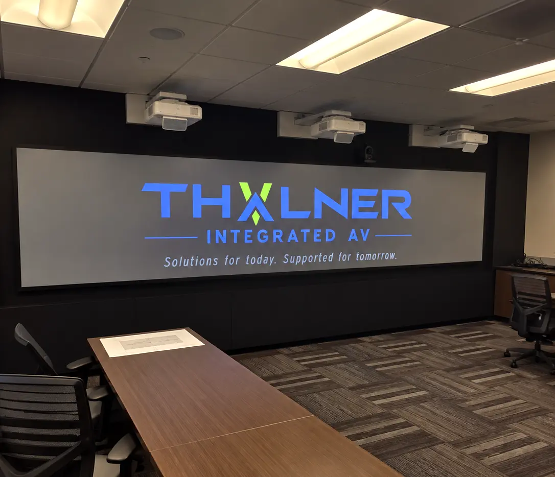 Conference room with three ceiling-mounted projectors edge-blended into one wide image