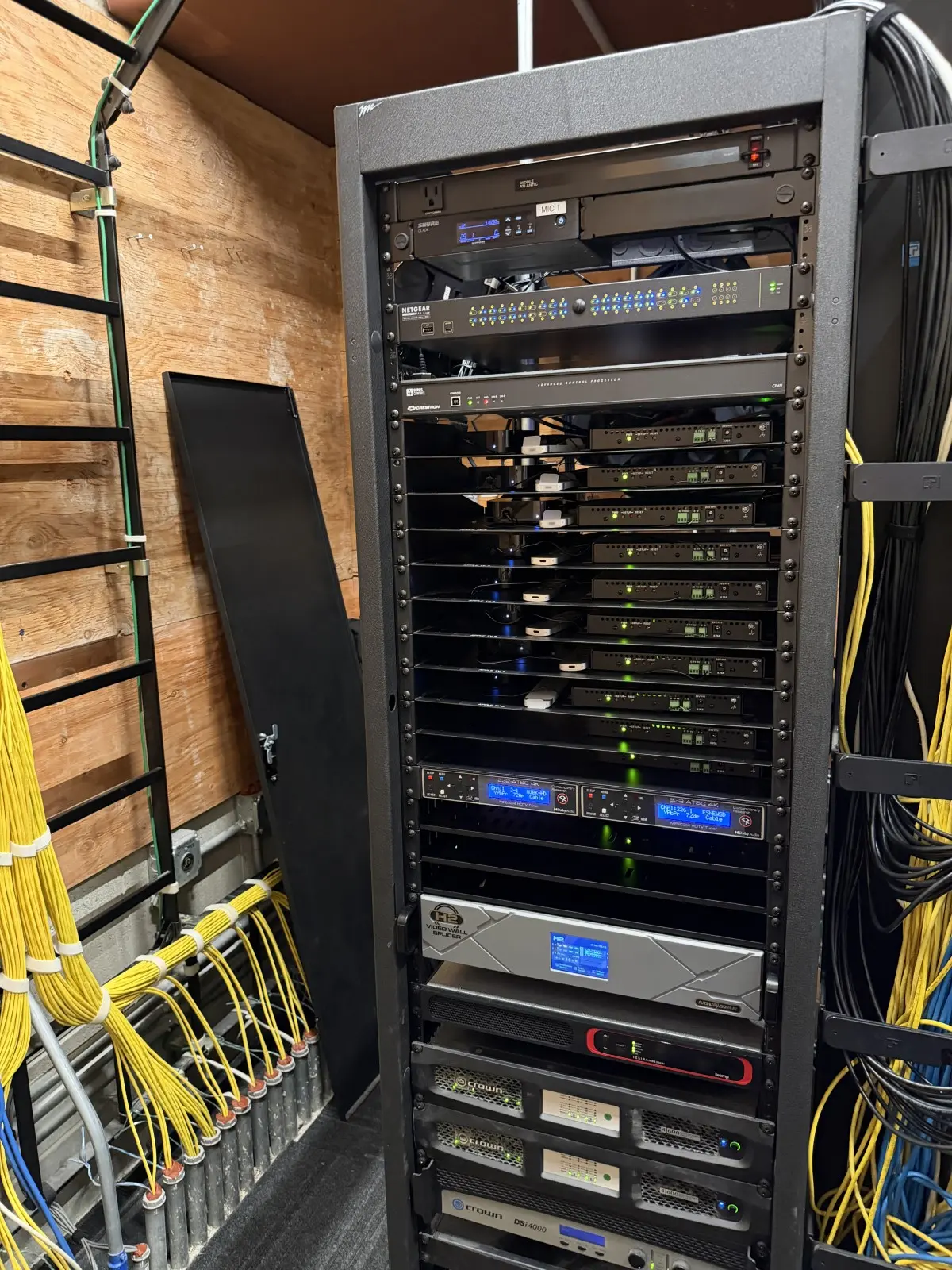 Equipment rack with a Crestron control processor, signal processing and amplifiers, cabling dressed down both sides
