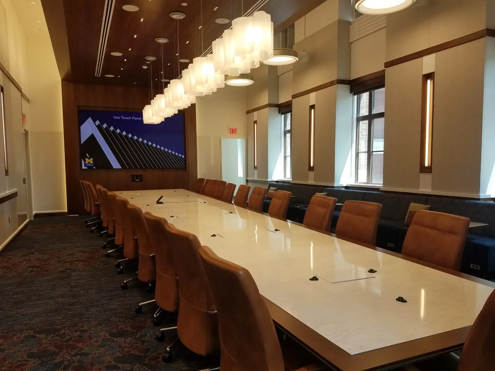 Long boardroom table with a large wall-mounted display and in-table connections